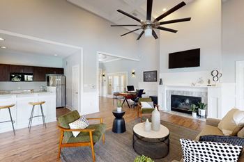 a clubhouse with a fireplace and a ceiling fan at Ashford Green, North Carolina