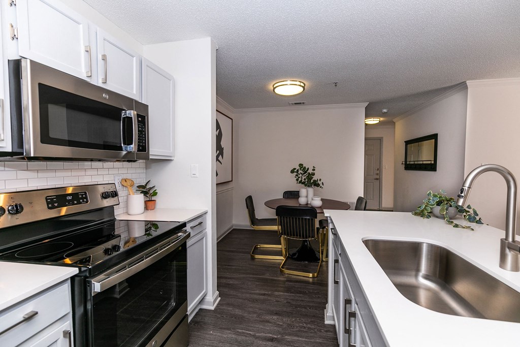 an open kitchen and dining room with stainless steel appliances and white cabinets an open kitchen and dining room with stainless steel appliances and white cabinets at Briarcliff Apartments, Atlanta, 30329