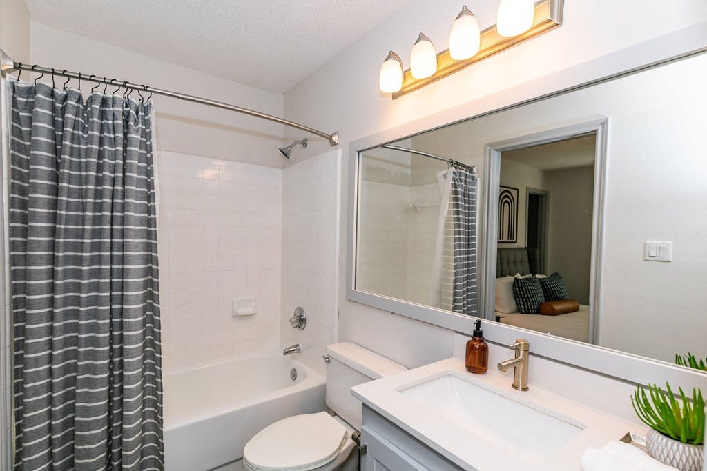 a bathroom with a sink and a mirror and a tub a bathroom with a sink and a mirror and a tub at Briarcliff Apartments, Georgia, 30329