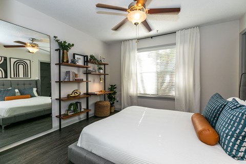 a bedroom with a bed and a ceiling fan