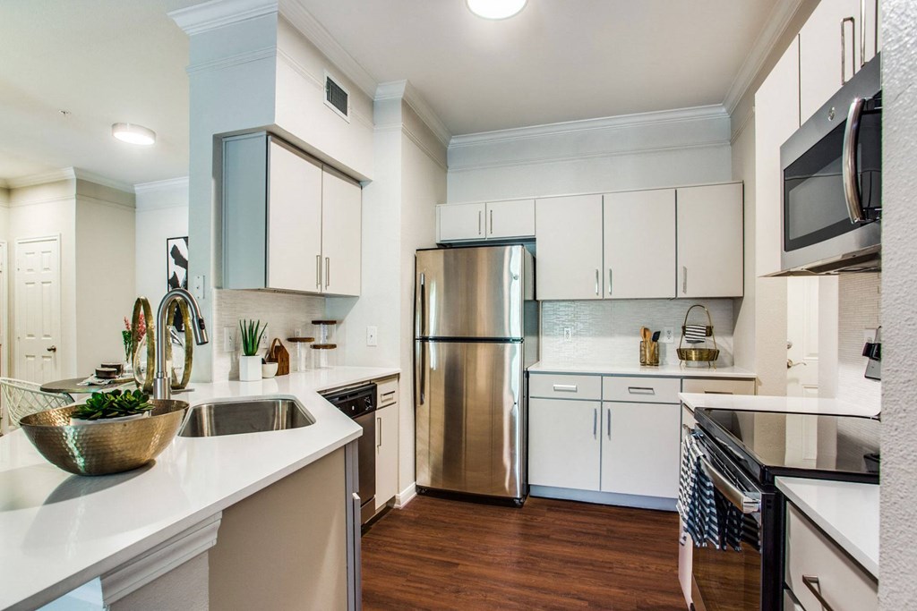 a kitchen with white cabinets and stainless steel appliances at Carrington at Barker Cypress, Cypress, TX