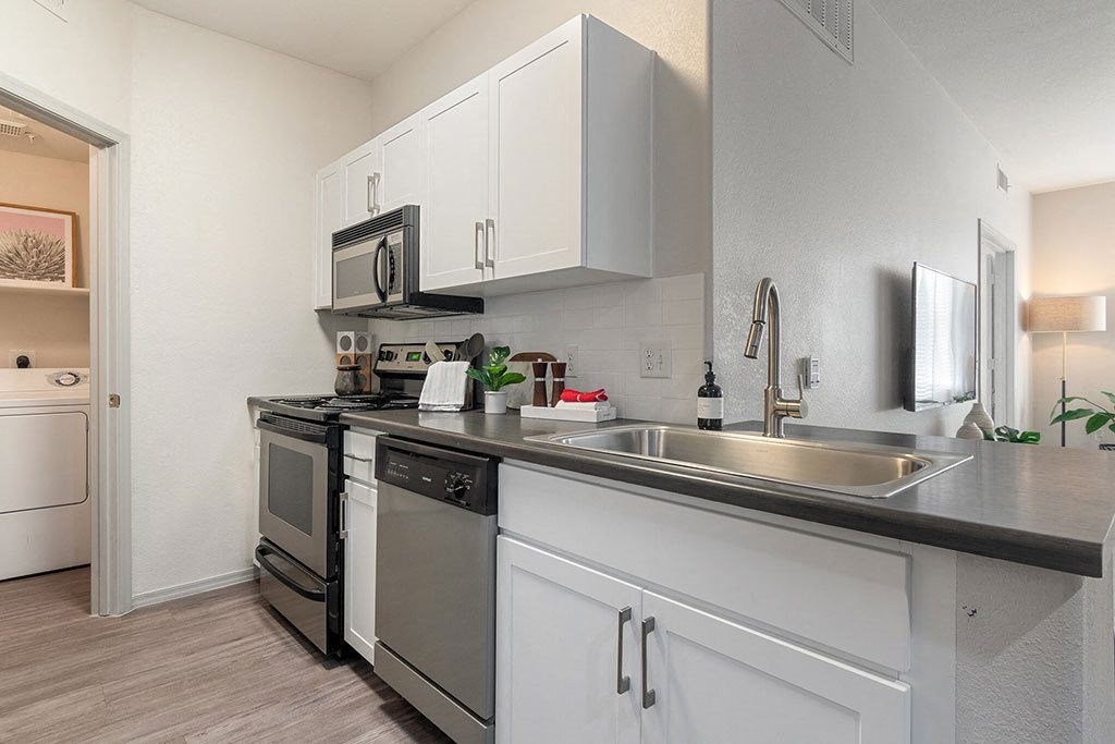 a kitchen with stainless steel appliances and white cabinets at Element Deer Valley, Phoenix
