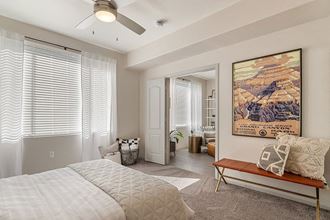 an empty room with a bed and a painting on the wall