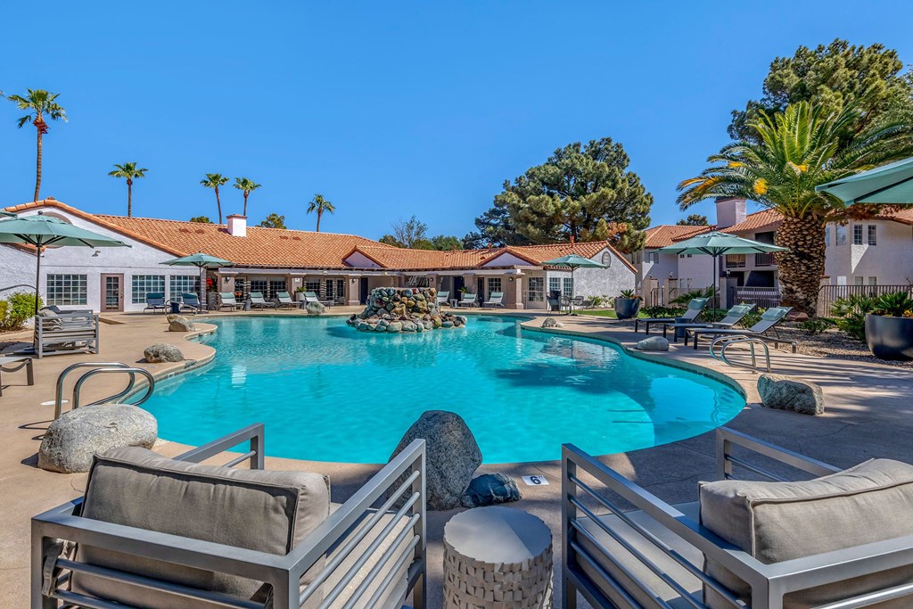 a large swimming pool with chairs and umbrellas at the resort
