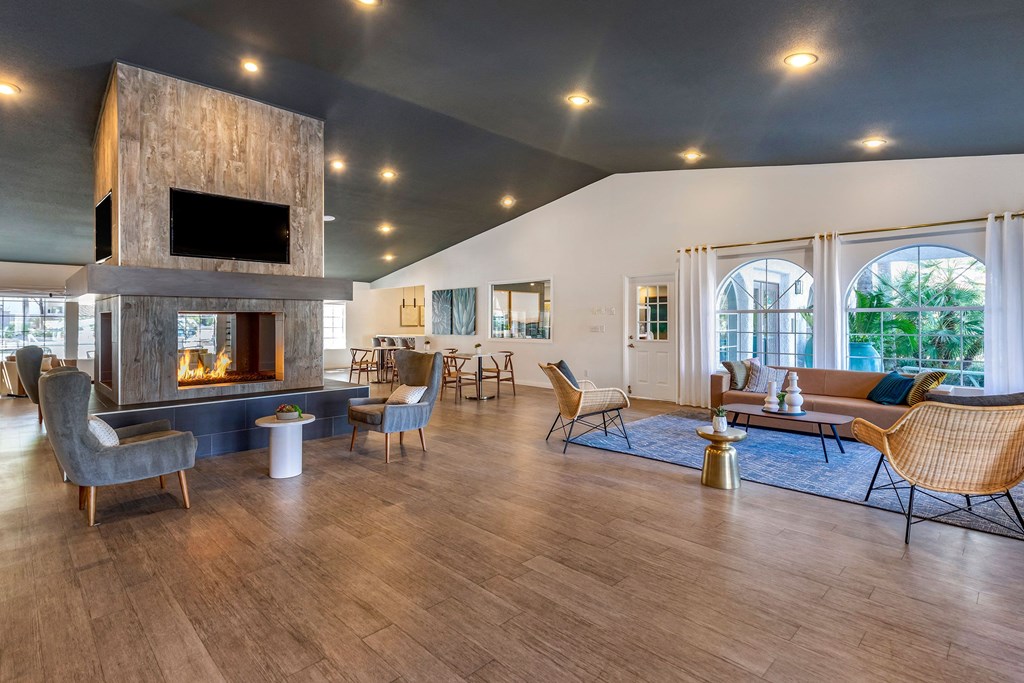 a large living room with a fireplace and chairs and tables