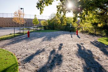 a dog park with a fence and two red fire hydrants at Heights at Glen Mills, Pennsylvania