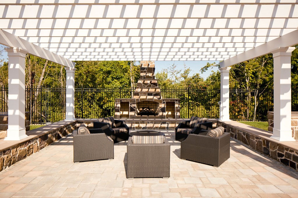 a pergola over a patio with furniture and a fireplace at Heights at Glen Mills, Glen Mills, PA