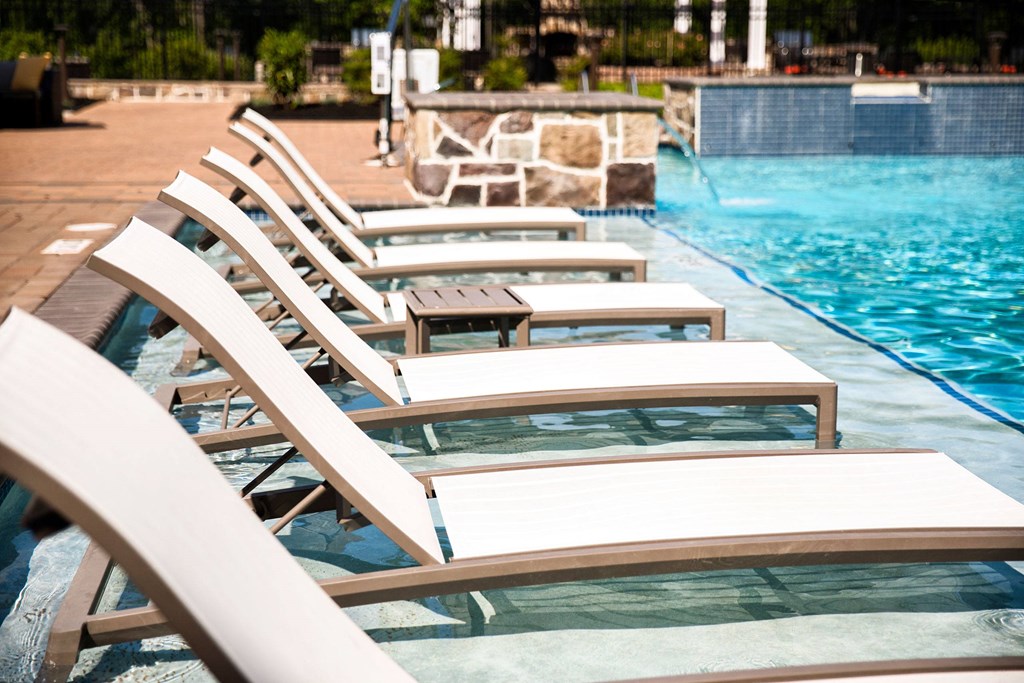 a row of beach chairs sitting next to a pool  at Heights at Glen Mills, Glen Mills, PA