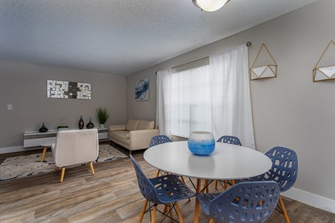 A dining room with a white table and blue chairs.