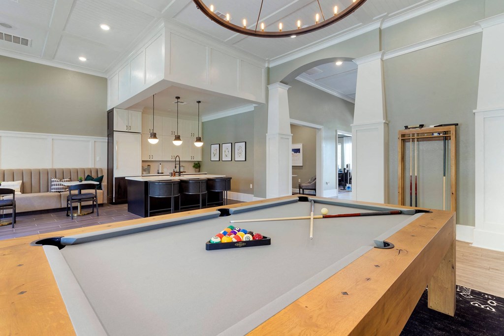 a pool table in the center of a living room with a kitchen at Madison on the Meadow, Texas