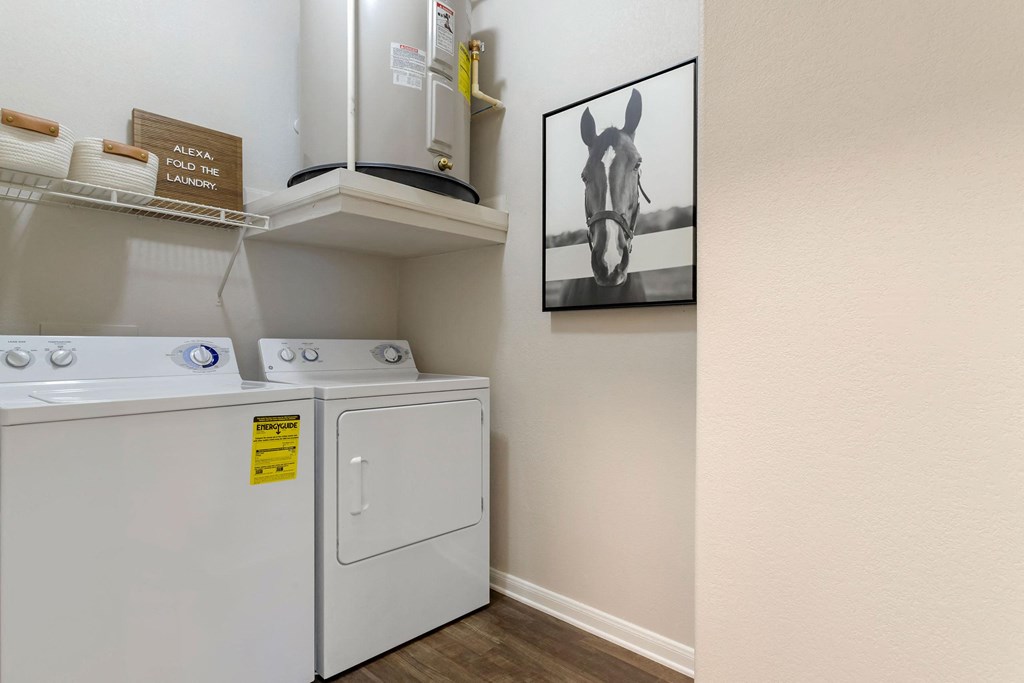 a laundry room with a washer and dryer and a painting on the wall at Madison on the Meadow, Stafford, Texas