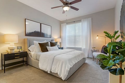 a bedroom with a large bed and a ceiling fan at Madison on the Meadow, Stafford, TX