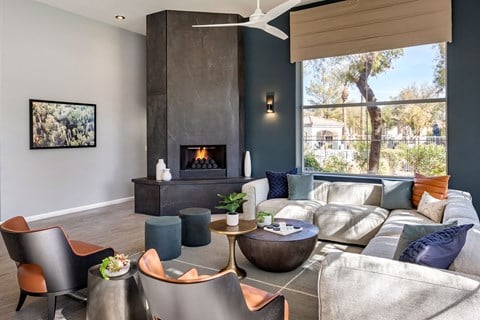 a living room with couches and chairs and a fireplace at Mirasol Apartments, Las Vegas, NV