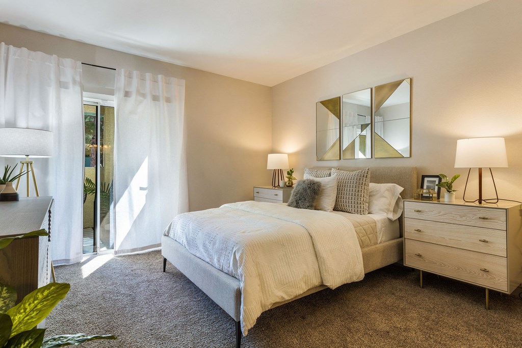 a bedroom with a bed and a door to a balcony at Mirasol Apartments, Las Vegas, 89119