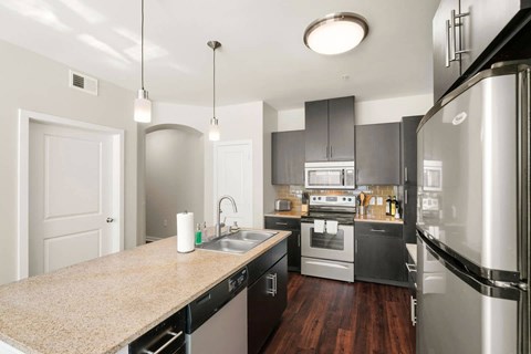a kitchen with stainless steel appliances and a counter top at Mockingbird Flats, Dallas, Texas
