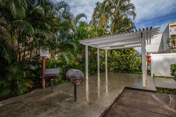 the backyard has a grill and a white canopy at Palms of Kilani Apartments, Wahiawa, Hawaii
