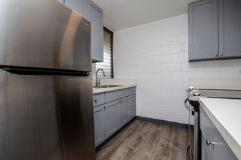 a kitchen with stainless steel appliances and white counter tops at Palms of Kilani Apartments, Wahiawa