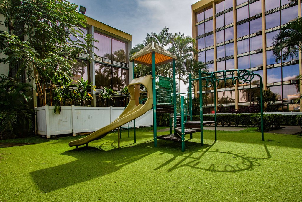 a playground with a slide next to a building at Palms of Kilani Apartments, Hawaii, 96786