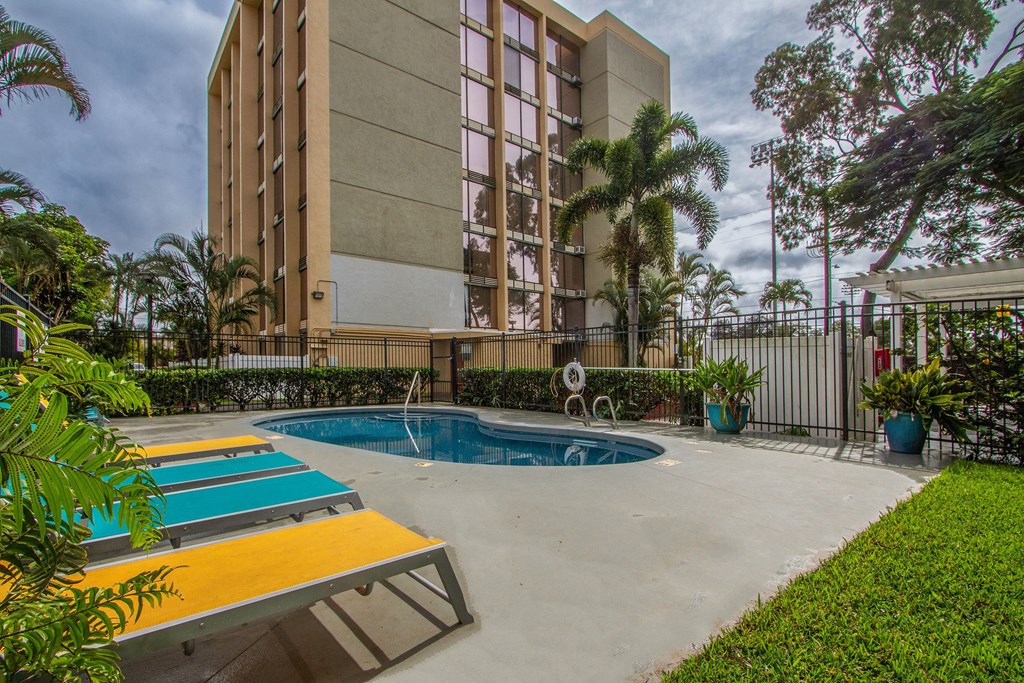 a resort style pool is next to a tall building at Palms of Kilani Apartments, Wahiawa, Hawaii