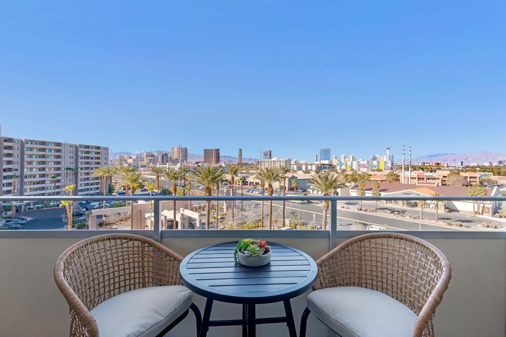 a balcony with two chairs and a table overlooking the city at The Rays at Vegas Towers Apartments, Las Vegas, 89119