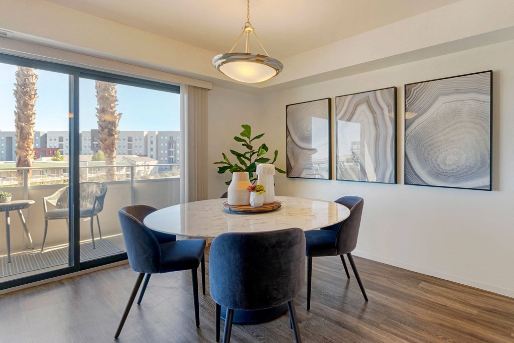 a dining room with a large window and a table with chairs at The Rays at Vegas Towers Apartments, Las Vegas, NV
