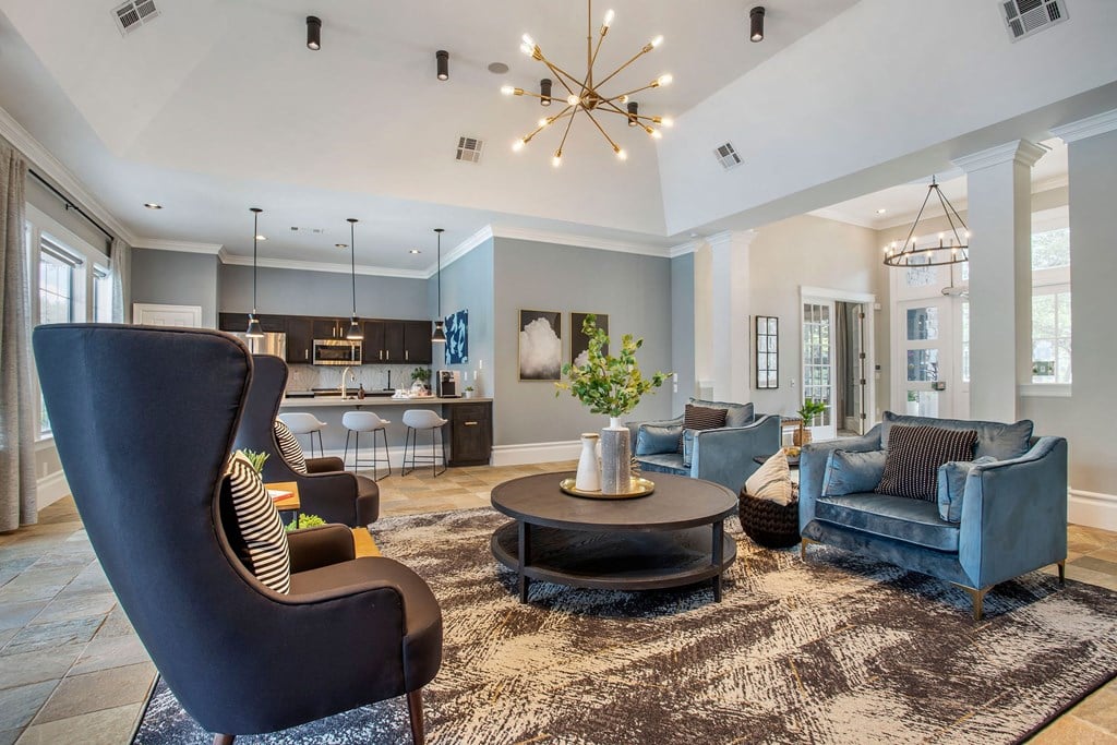 a living room with blue furniture and a chandelier at Reserve by the Lake, Houston