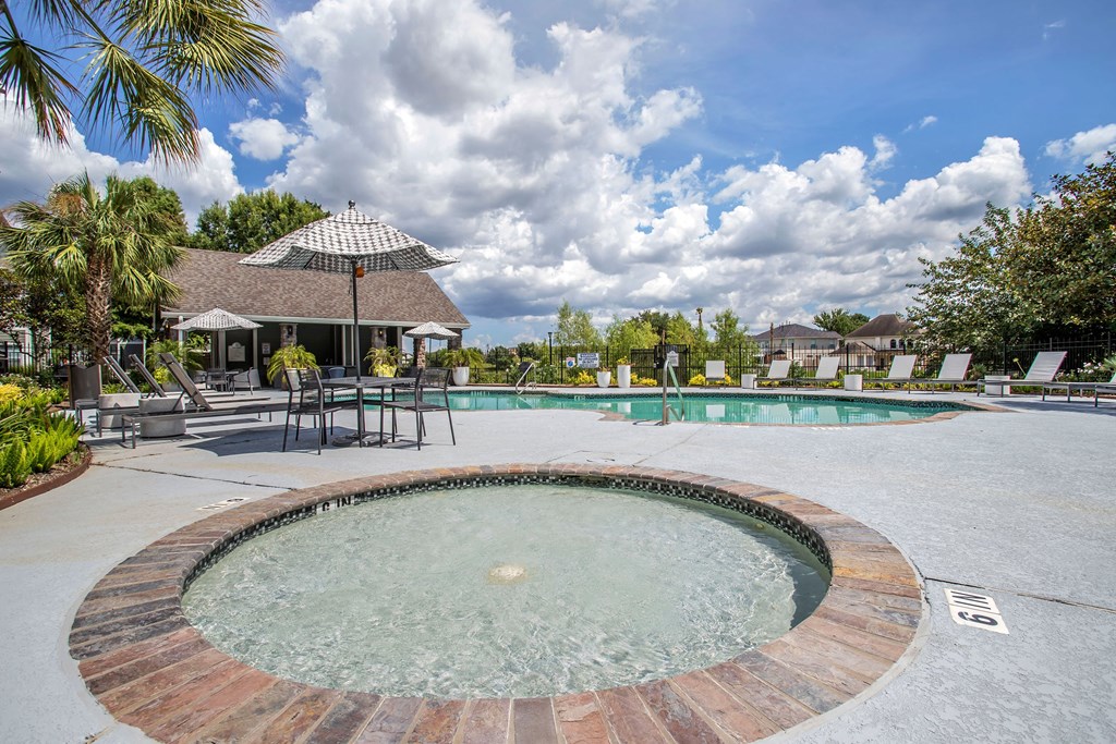 In Ground Hot tub with View of the Pool with chairs and an umbrella at Reserve by the Lake, Texas