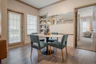 a dining room with a table and chairs in front of a window