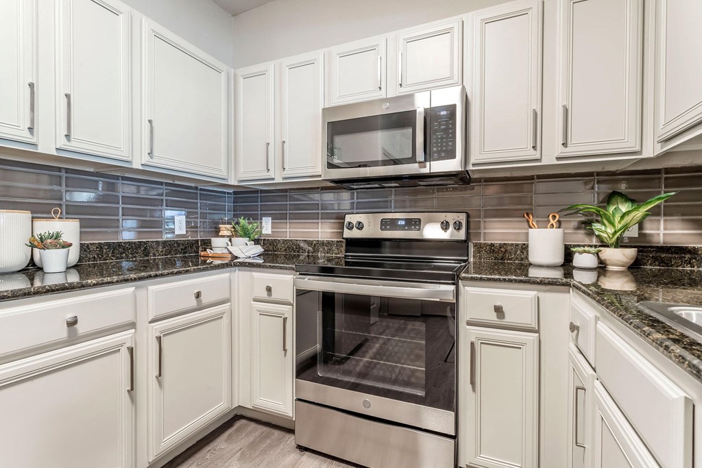 a kitchen with white cabinets and stainless steel appliances a kitchen with white cabinets and stainless steel appliances at Reserve by the Lake, Houston, Texas