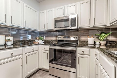 a kitchen with white cabinets and stainless steel appliances at Reserve by the Lake, Houston, Texas