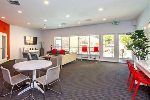 a lounge area with chairs and tables and windows at Skyview Apartments, Westminster, CO