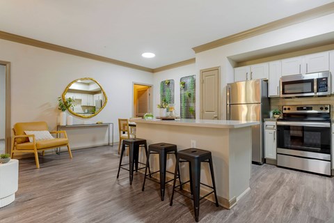 a kitchen with a large island with three stools at Summerwind, Pearland, 77584