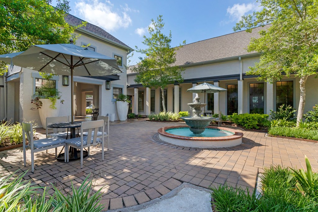 a patio with a fountain and a table and chairs at Summerwind, Pearland Texas