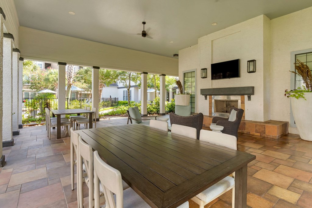 a dining room with a table and chairs and a fireplace at Summerwind, Pearland