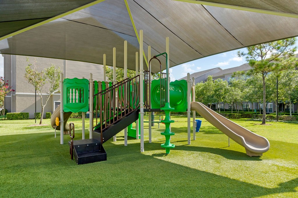 a playground with a play set under a canopy at Summerwind, Pearland, TX