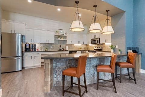 a kitchen with a large island with three chairs at Summerwind, Pearland, TX 77584