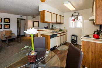 the view of a kitchen and dining room with a table and chairs at Sunset Winds Apartments, Henderson, 89014