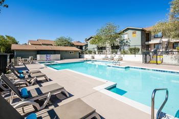 our apartments have a resort style pool with lounge chairs at Sunset Winds Apartments in Henderson, NV 89014