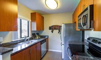 a kitchen with granite countertops and stainless steel appliances at The Lakes Apartments, Bellevue, WA