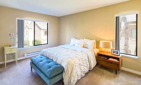 a bedroom with a bed and two windows at The Lakes Apartments, Bellevue Washington