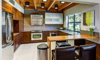 a spacious kitchen with a wooden ceiling and white tiles on the floor at The Lakes Apartments, Bellevue