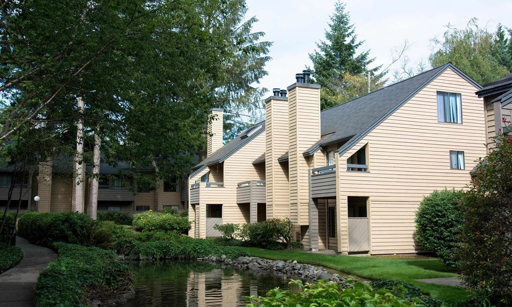 a large building with a pond in front of it at The Lakes Apartments, Washington, 98007