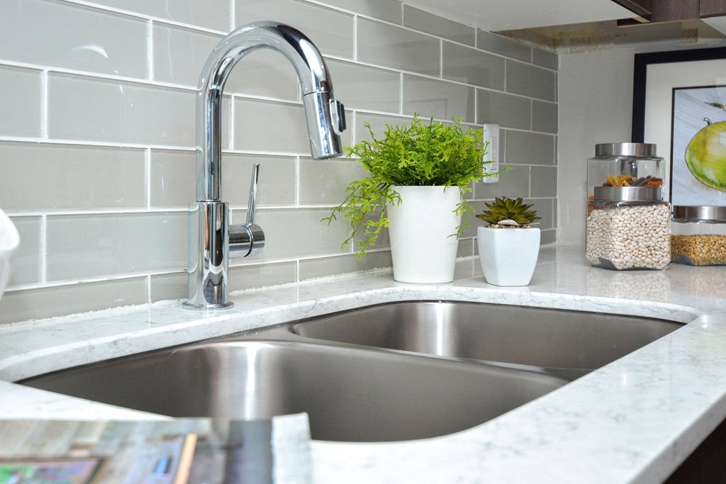 a stainless steel kitchen sink with a chrome faucet at Apartments at Denver Place, Colorado, 80202