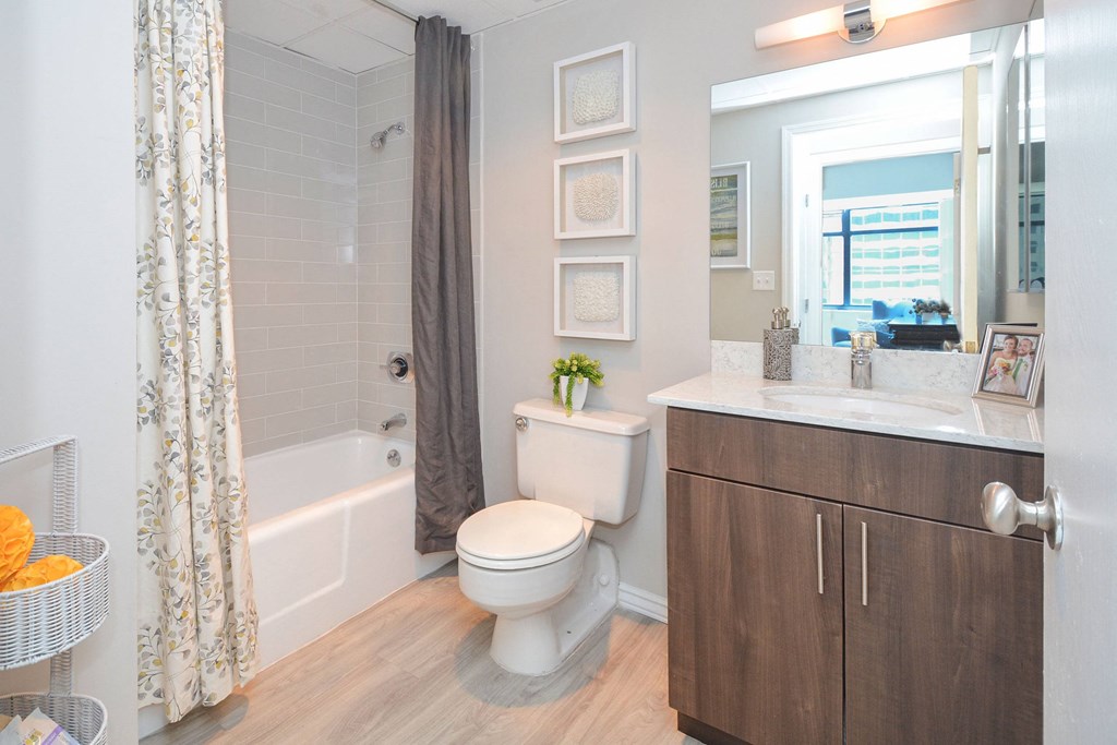 a bathroom with a shower and a toilet and a sink at Apartments at Denver Place, Denver