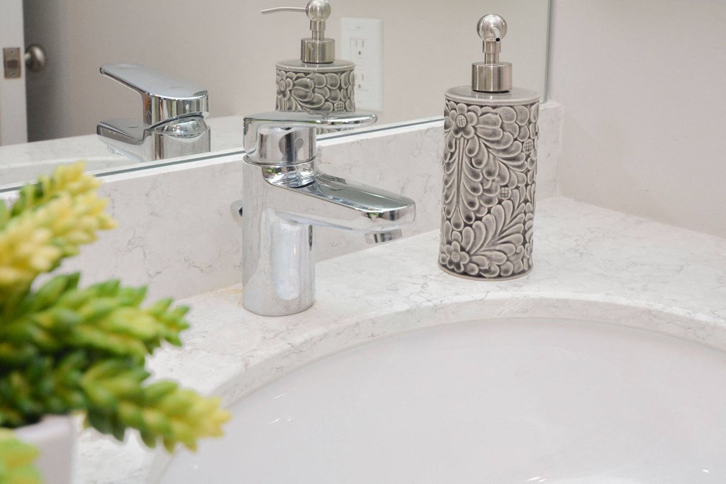 a bathroom with a sink and a soap dispenser on it at Apartments at Denver Place, Denver Colorado
