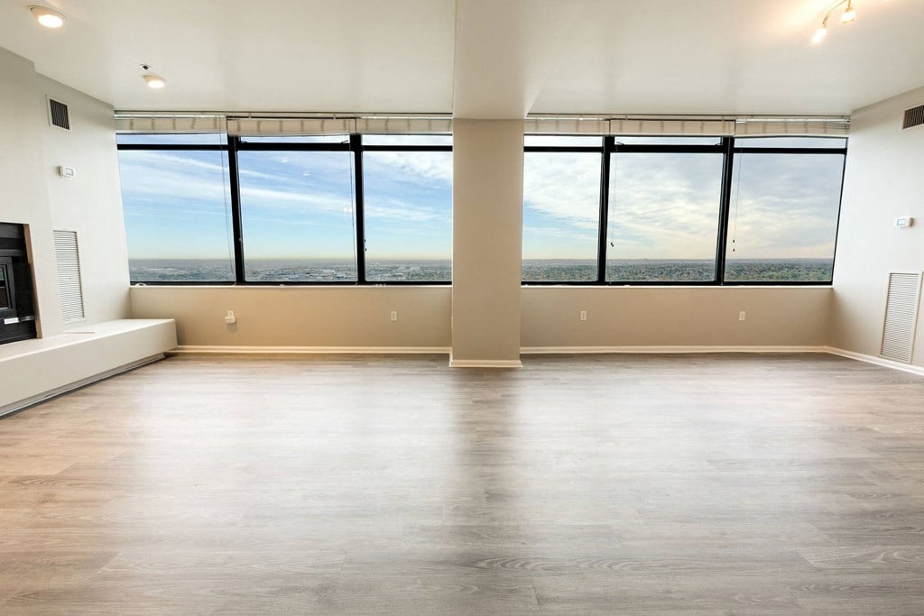 an empty living room with a window view of the city at Apartments at Denver Place, Denver, CO 80202