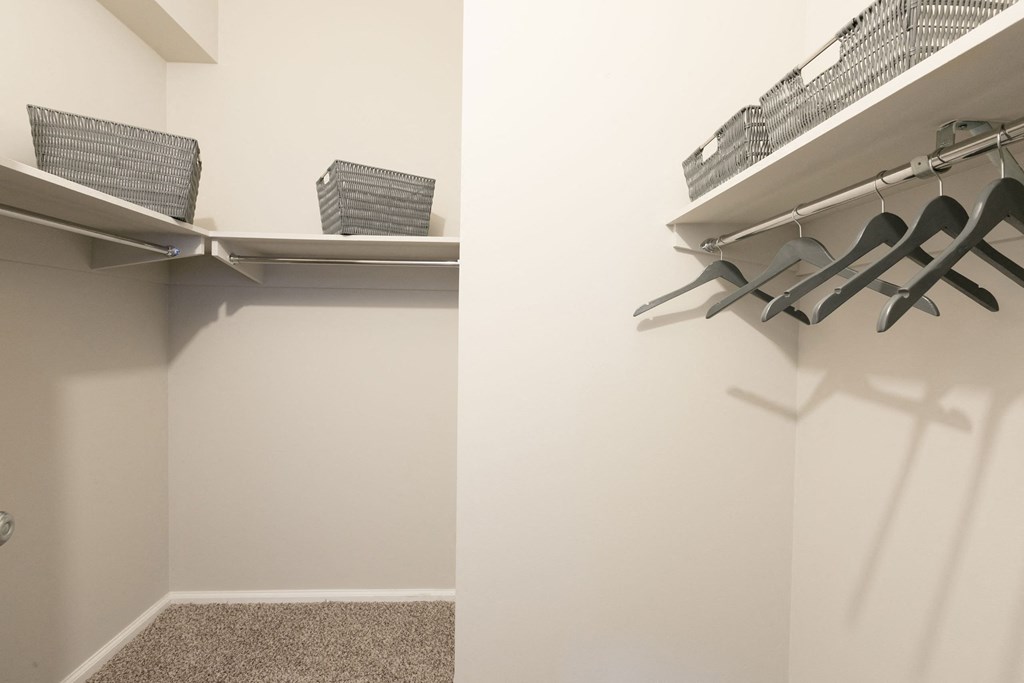 a walk in closet with chairs and a shelf on the wall at Apartments at Denver Place, Colorado, 80202