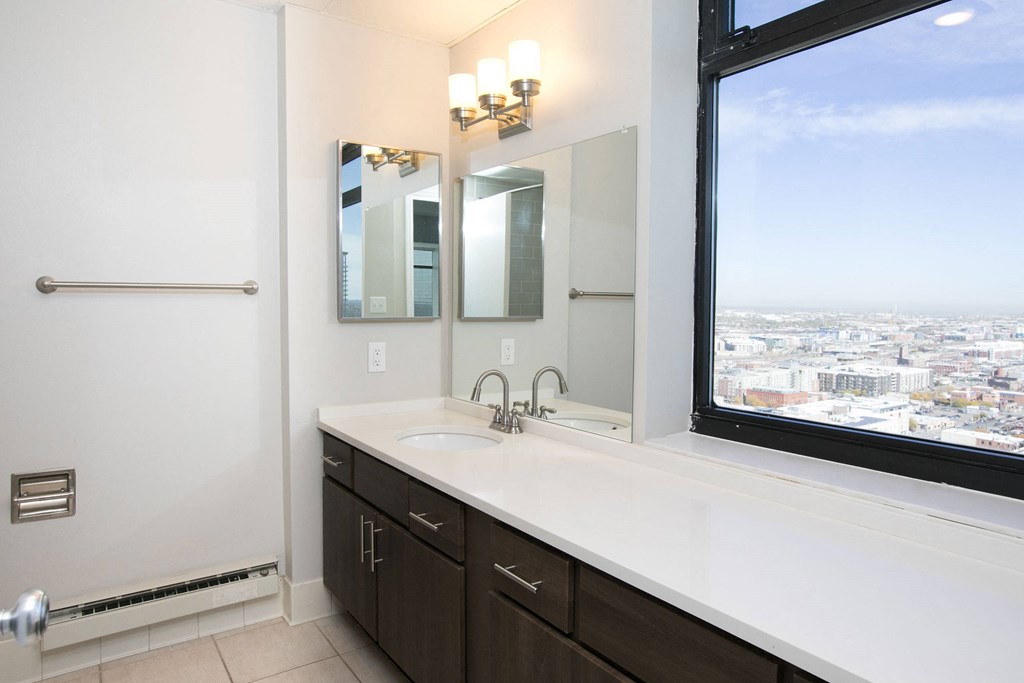 a bathroom with a large window and a sink and mirror at Apartments at Denver Place, Colorado