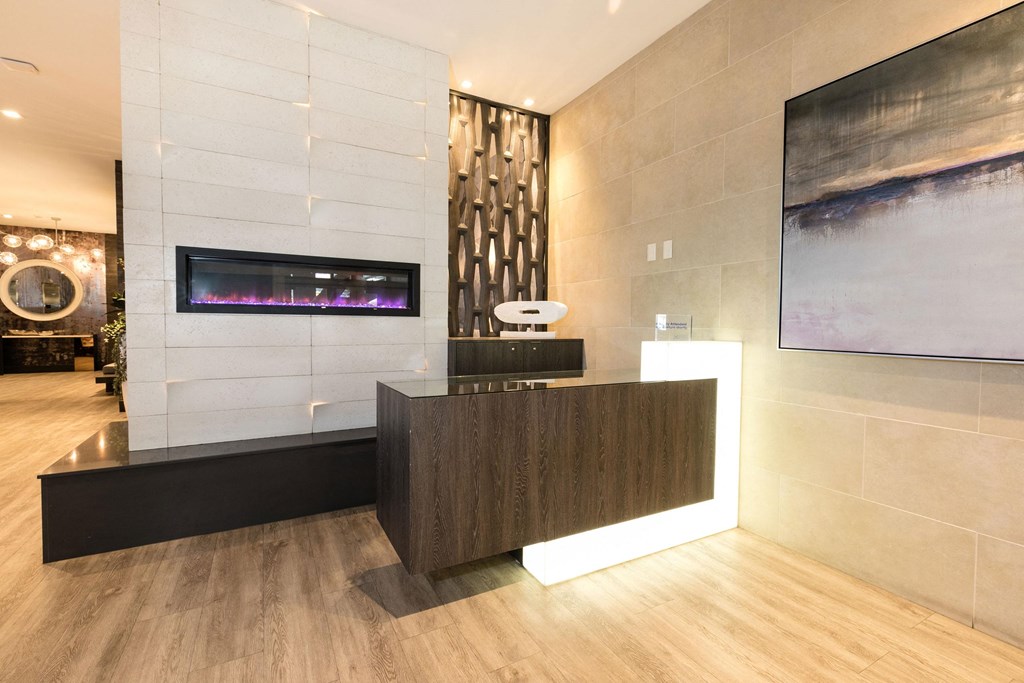 the lobby of a hotel with a reception desk and a fireplace  at Apartments at Denver Place, Denver Colorado
