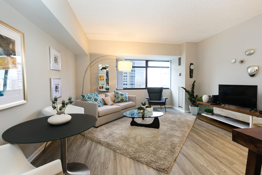 a living room with a couch and a table and a television at Apartments at Denver Place, Colorado, 80202